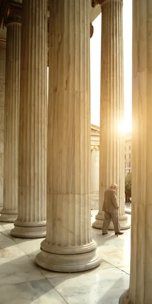 Senior Figure Strolling Through Marble Columns in Sunlight
